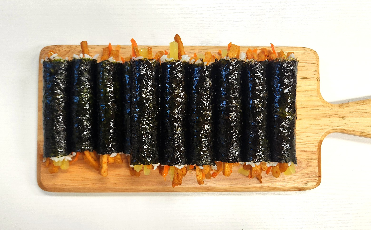 mini kimbap recipe (kkomagimbap) bite-sized Korean gimbap rolls on wooden board