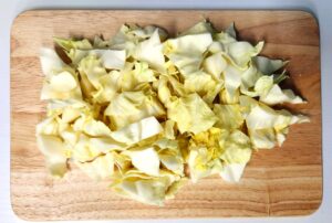 chopped cabbage on cutting board ready for cooking